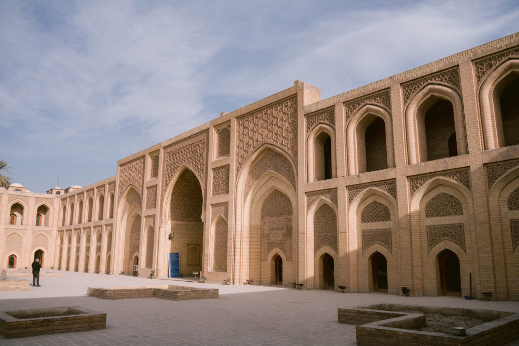 Courtyard of Al-Mustansiriya School in Baghdad, Iraq, showcasing intricate Islamic architecture, arched windows, and detailed brickwork from the Abbasid era.