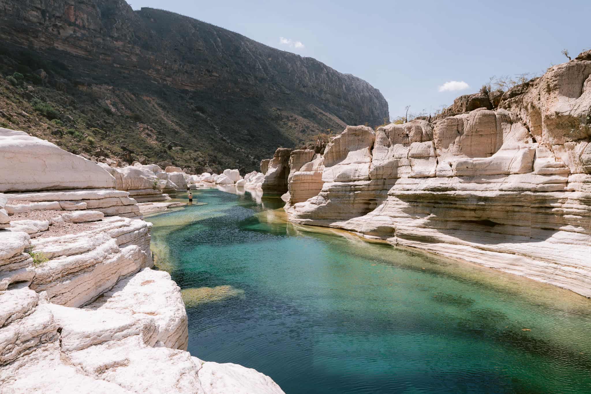 Exploring Wadi Kalisan, one of the best things to do in Socotra, with clear turquoise pools surrounded by rocky cliffs and lush greenery in the island’s interior.