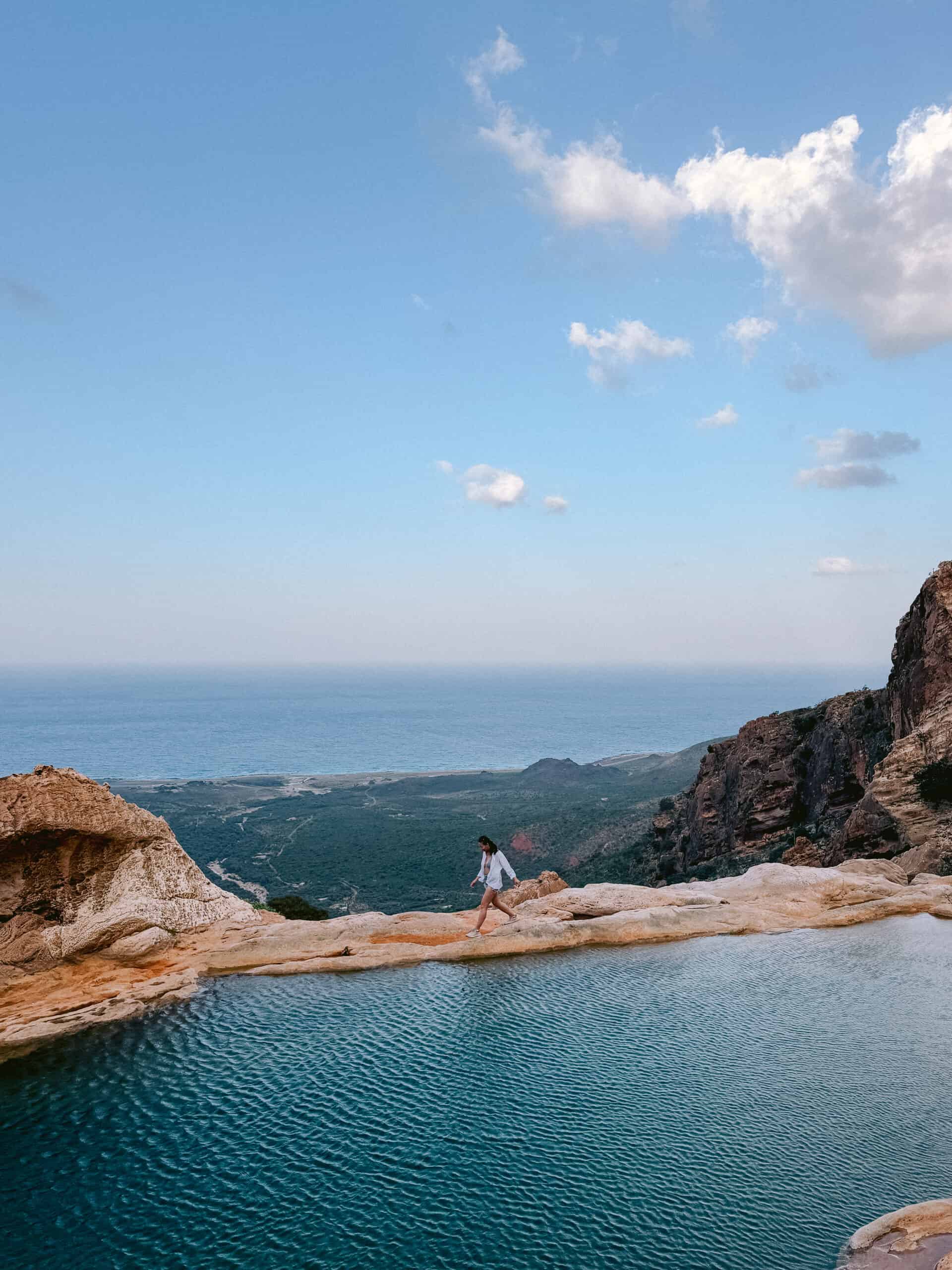 Hiking to the natural infinity pool at Homhil in Socotra, Yemen, with panoramic views of the Arabian Sea — a breathtaking stop on any list of things to do in Socotra for adventure and nature lovers.