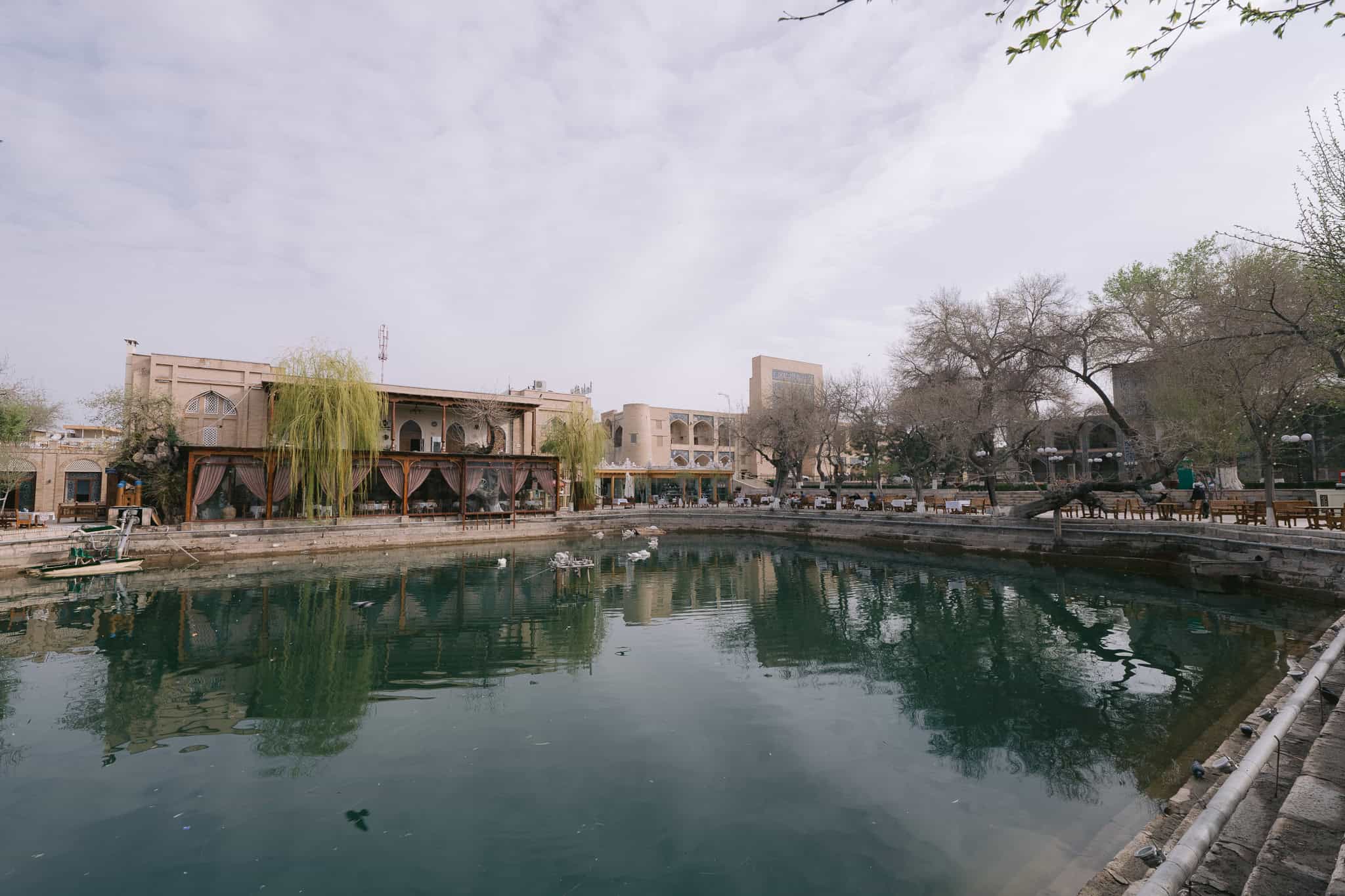 Lyabi Hauz pool surrounded by cafes and historic buildings in Bukhara, Uzbekistan.