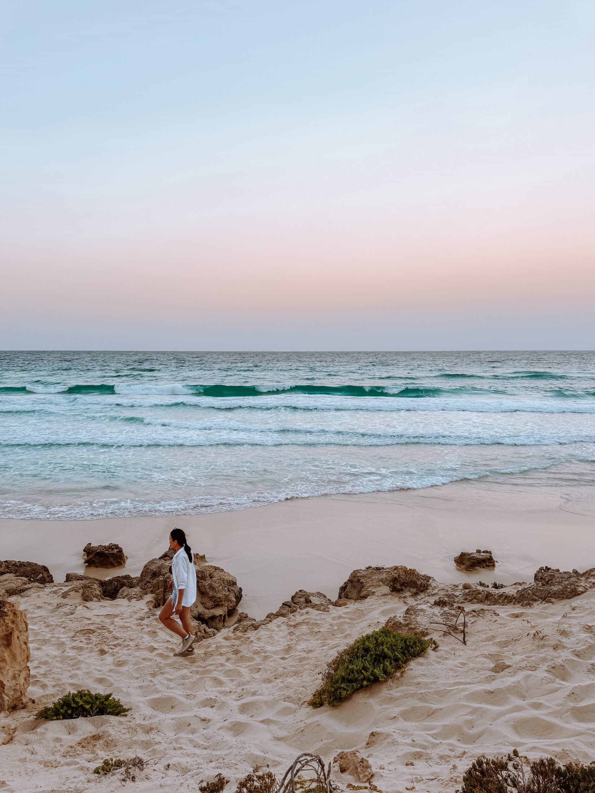 Traveler walking along Socotra’s Arher beach at sunset.