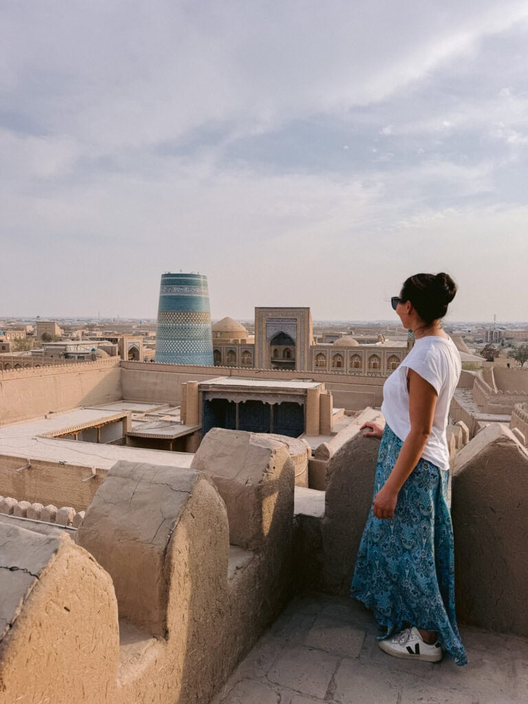 Solo female traveler overlooking Khiva’s skyline at sunset, confirming Uzbekistan feels safe for women.