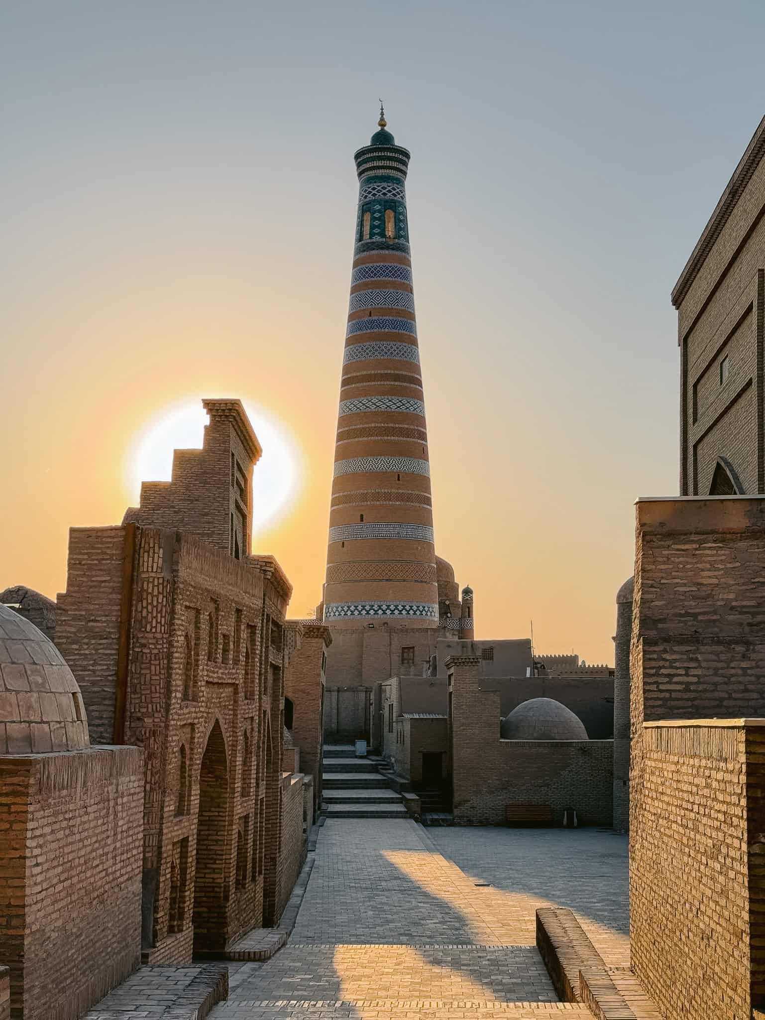 The tall Islam Khodja Minaret in Khiva glowing in the sunrise — a stunning view that captures the magic of the Silk Road city.
