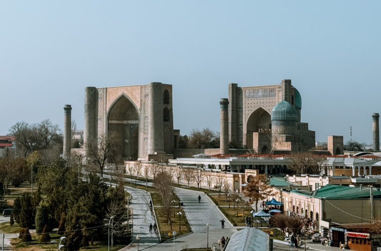 Panoramic view of Registan Square in Samarkand from across the park walkway