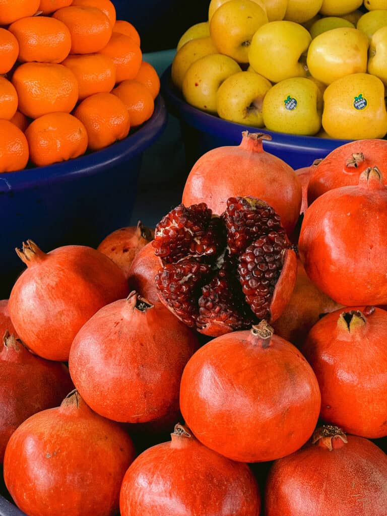 Fresh pomegranates and citrus fruits for sale at an Uzbek market