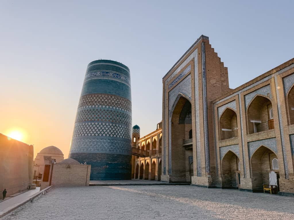 Sunrise over Kalta Minor Minaret and madrasa rooftops in Khiva’s Itchan Kala, Uzbekistan
