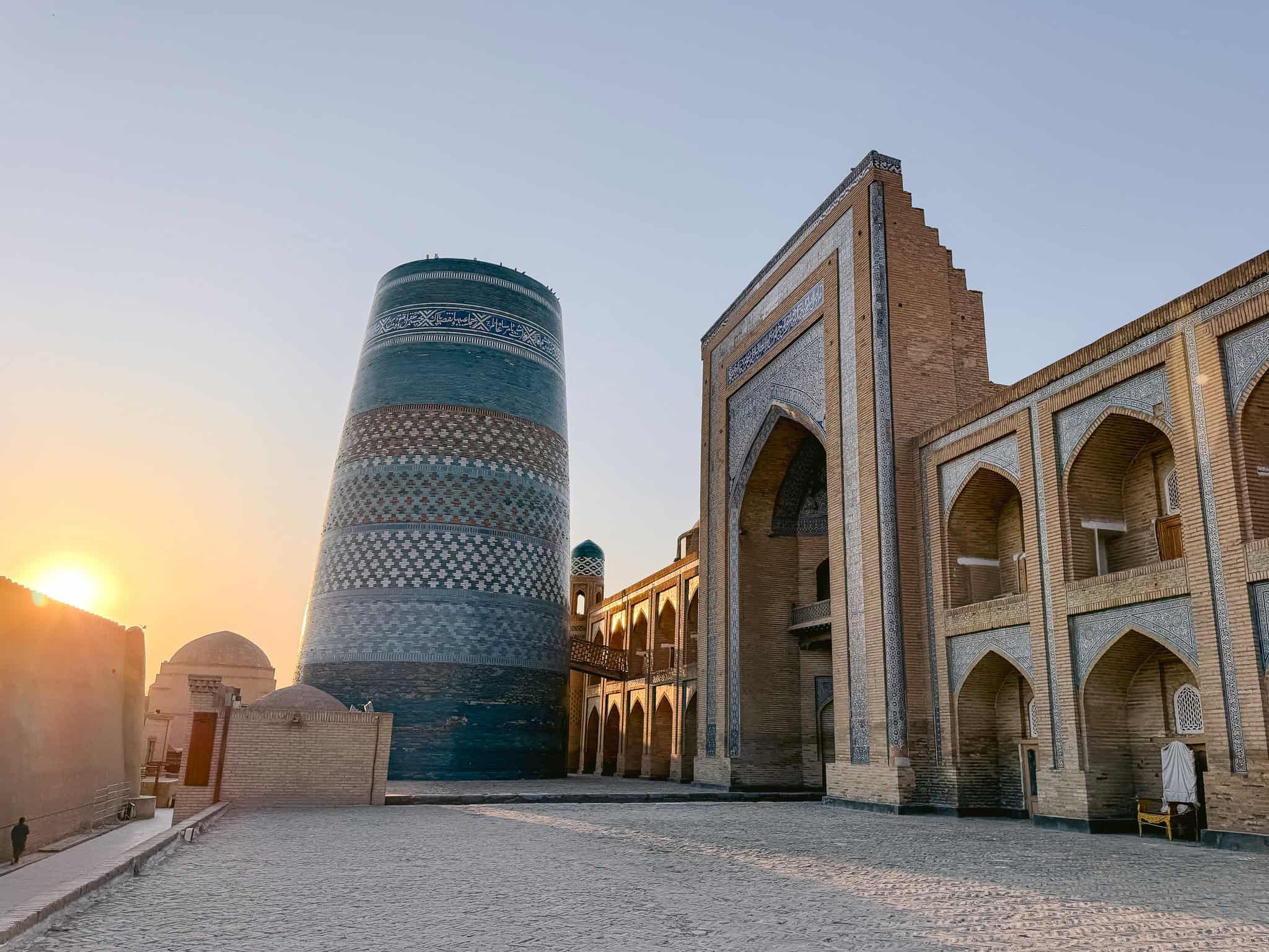 Sunrise over Kalta Minor Minaret and madrasa rooftops in Khiva’s Itchan Kala, Uzbekistan