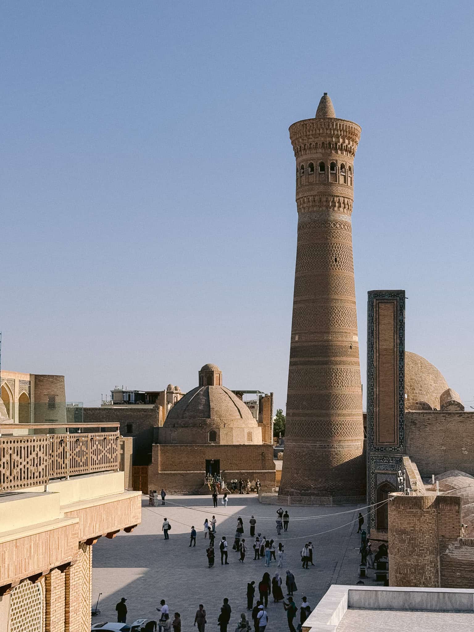 Kalyan Minaret towering over Po-i-Kalyan complex in Bukhara with people in the square