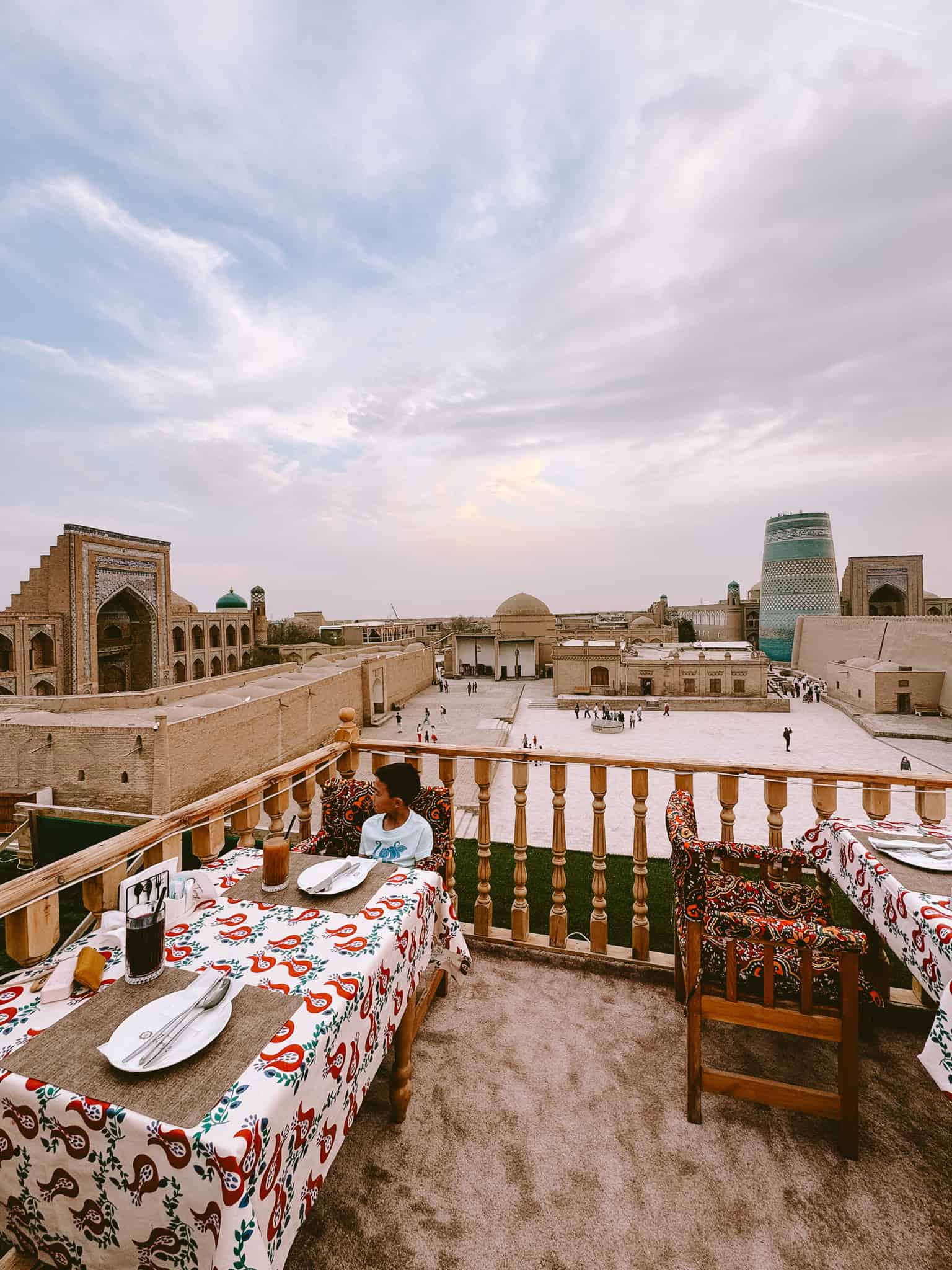 Dining at a rooftop restaurant in Khiva with panoramic views of the old town and Kalta Minor Minaret