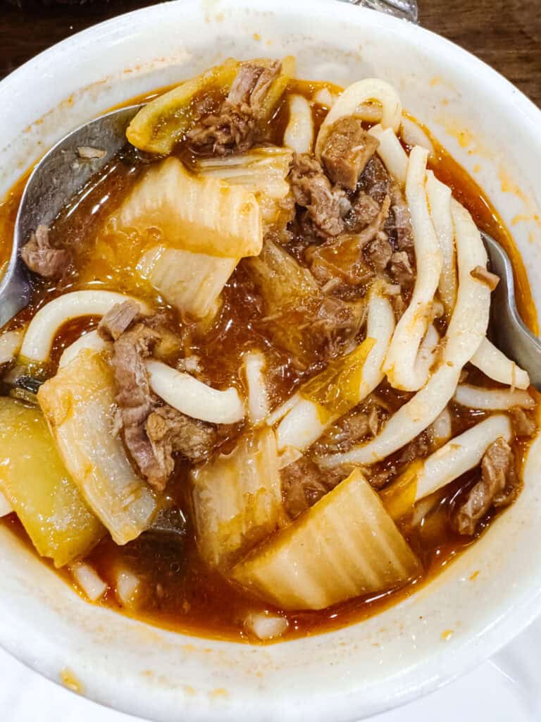 Traditional Uzbek laghman noodle soup with hand-pulled noodles, beef, and vegetables