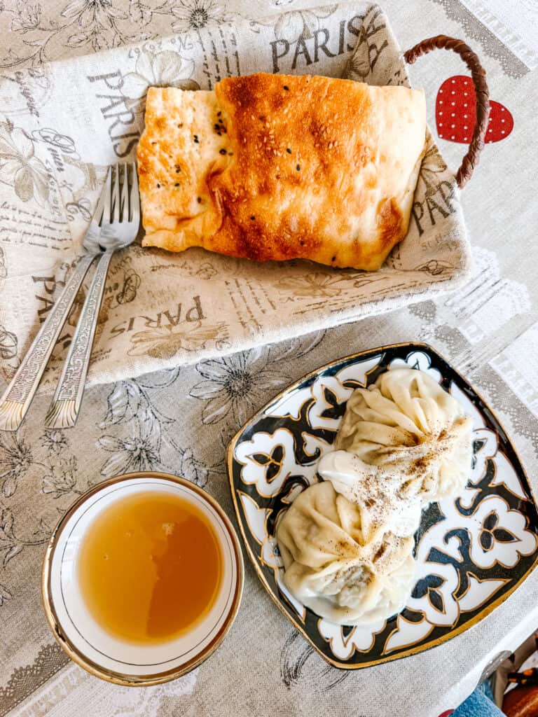 Traditional Uzbek meal of fresh non bread, manti dumplings and tea