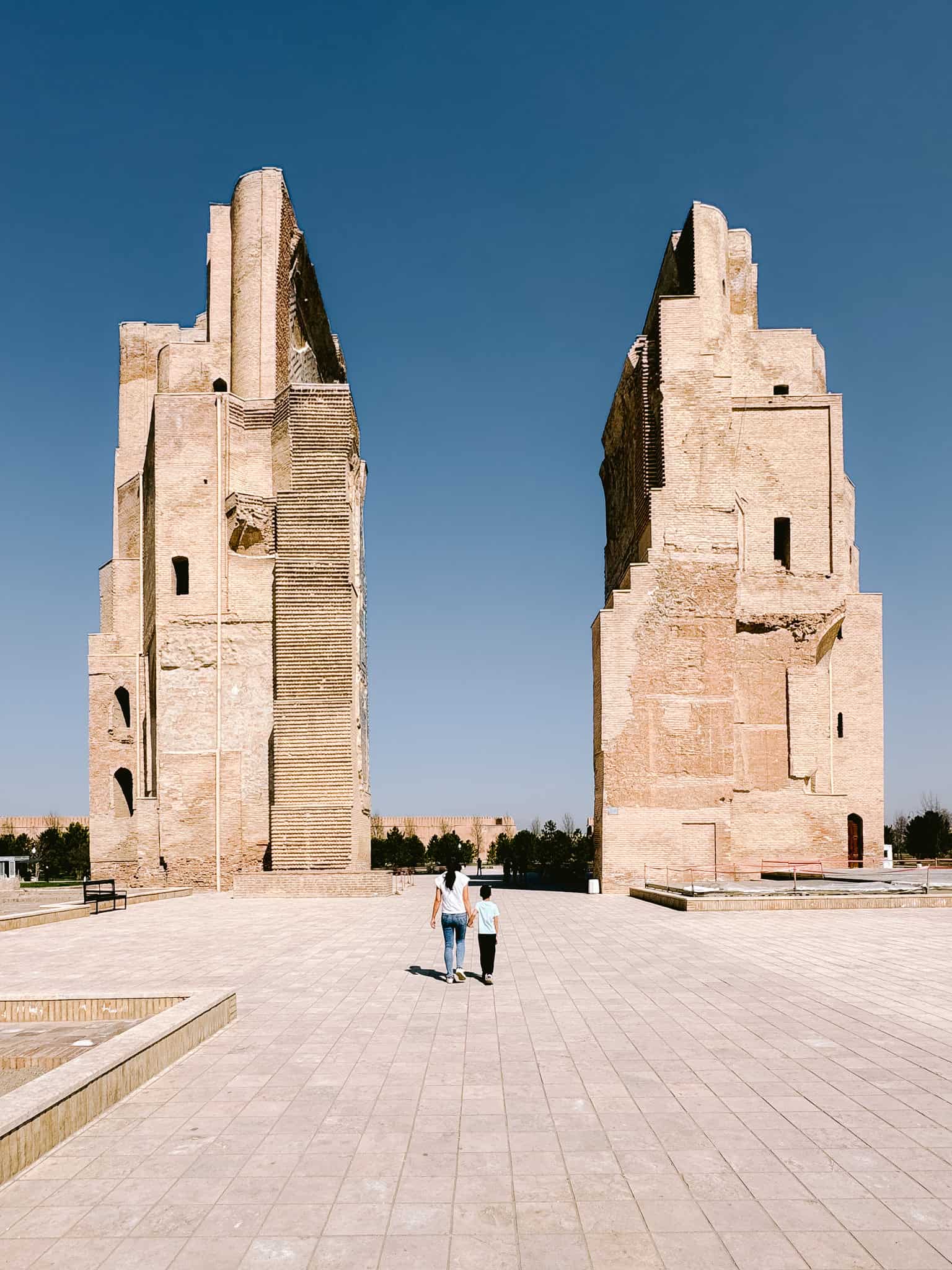 Mother and child walking safely through the ruins of Shahrisabz, proving Uzbekistan is safe for women and families.